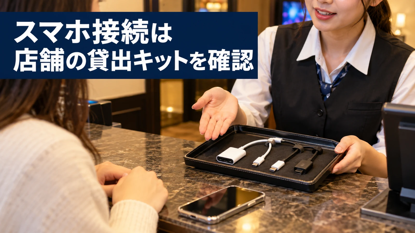 受付でスマホと貸出接続キットを確認する様子