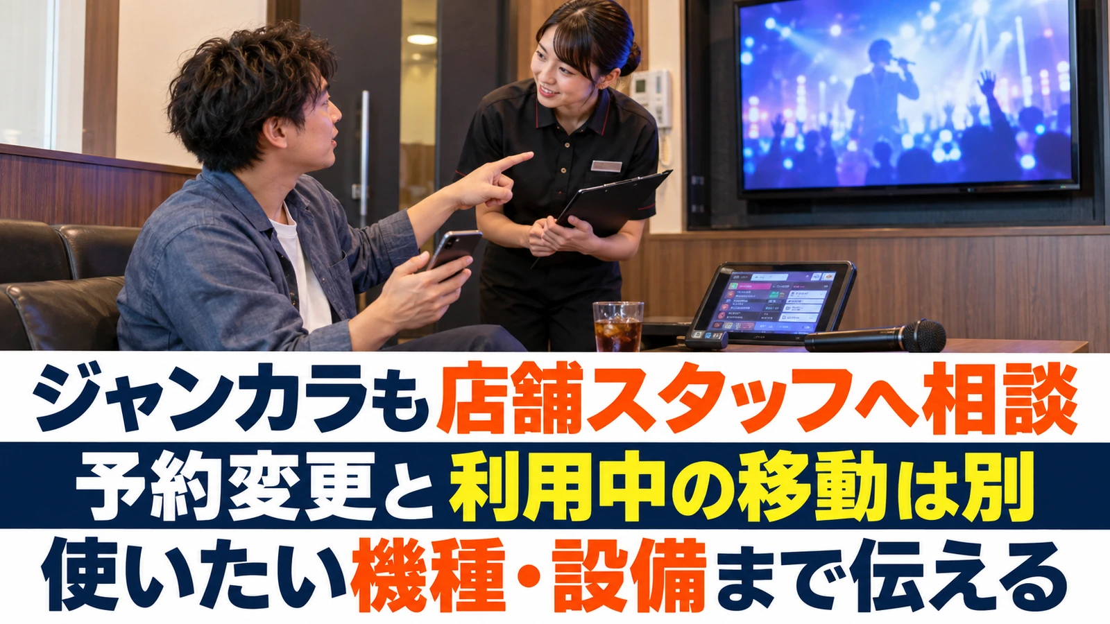 カラオケのモニターを示し希望する設備についてスタッフに相談する男性