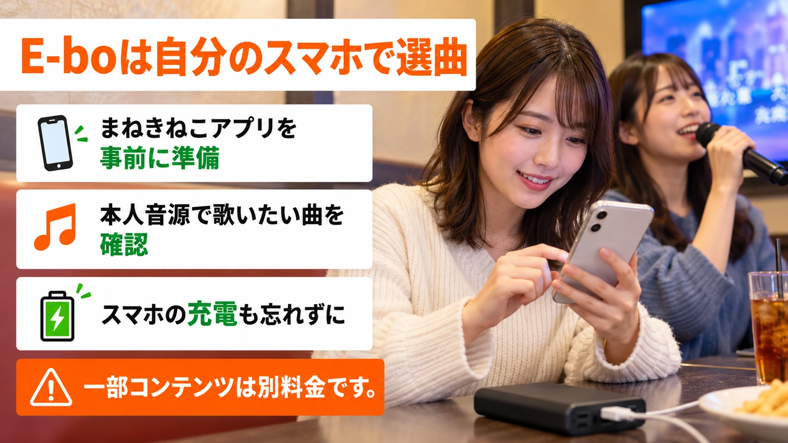 スマートフォンで選曲しながら友人とカラオケを楽しむ女性